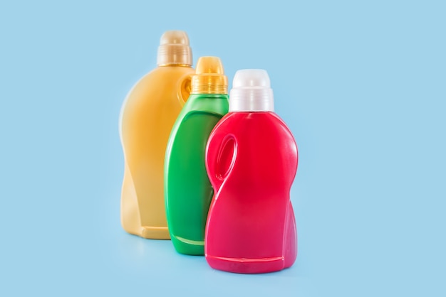 Detergents bottles on a blue background. Liquid detergent for laundry in colored containers.