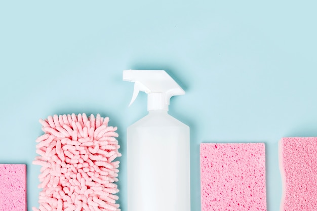 Detergents and cleaning accessories  in pink color.  Cleaning service concept. Flat lay, Top view.