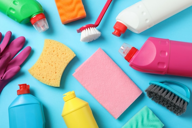 detergents and cleaning supplies on blue background, top view