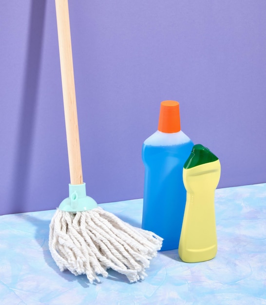 Detergents and a mop with a white floor mop on a purple background