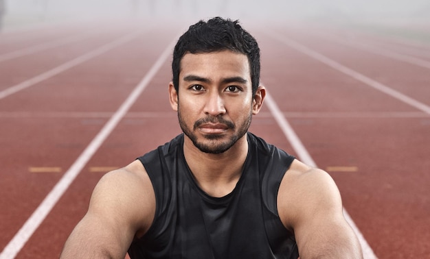 Determination always gets me that win Shot of a young male athlete sitting on the track before a race