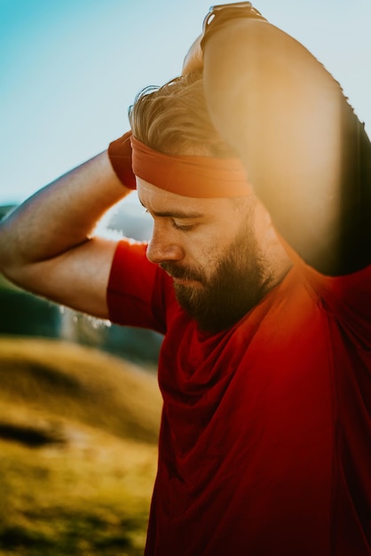 Foto un atleta determinato che si prepara per l'inizio dell'allenamento in cima alla montagna all'alba.