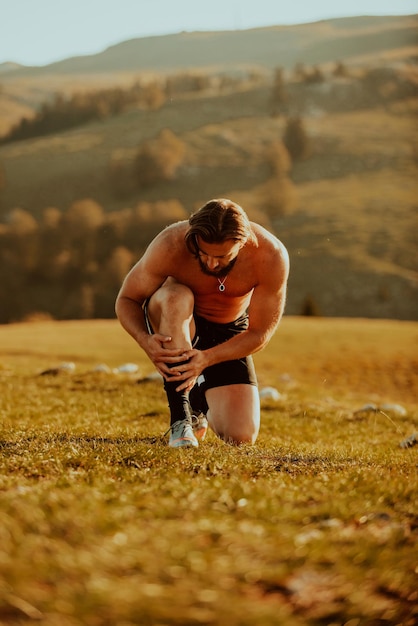 A determined athlete preparing for the start of training on the top of the mountain at sunrise