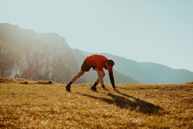 A determined athlete preparing for the start of training on the top of the mountain at sunrise