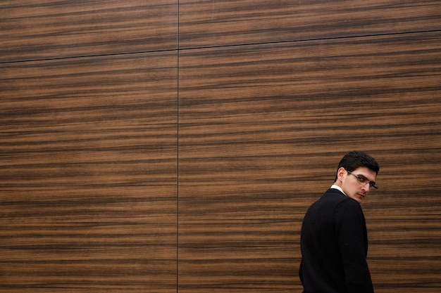 determined concentrated serious business man. modern smart professional worker. wood texture wall background. outdoors street. copyspace concept