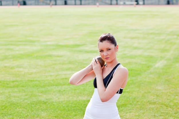 Determined female athlete holding weight