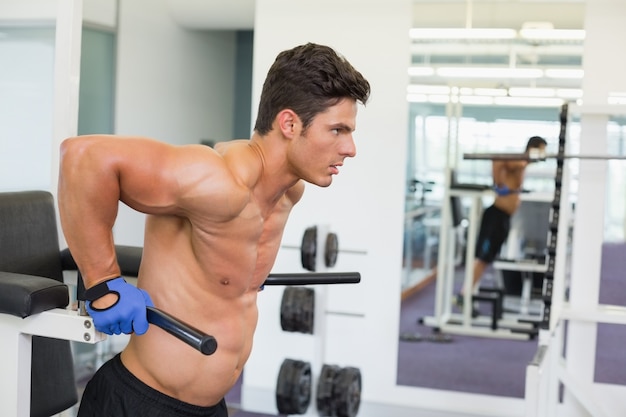 Determined muscular man doing crossfit fitness workout in gym