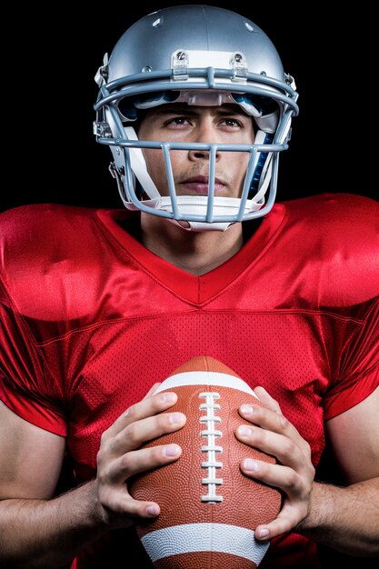 Determined sportsman holding American football