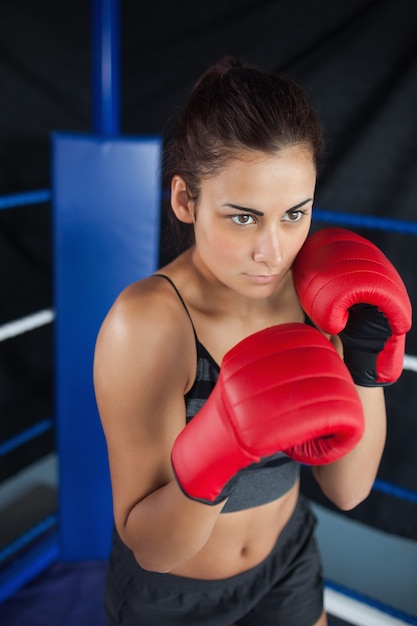 Determined woman in red boxing gloves