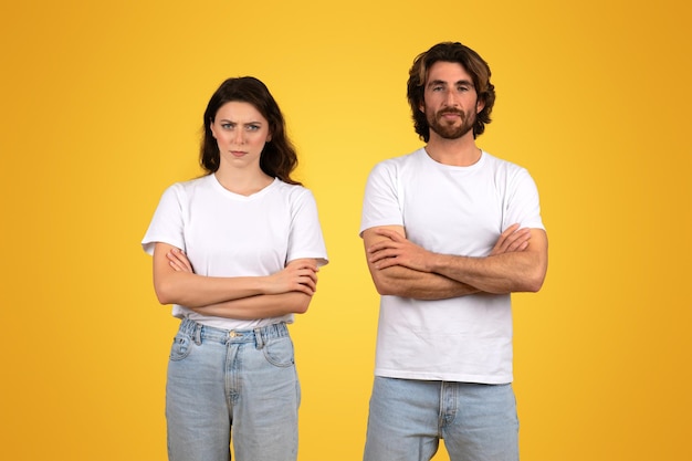 Determined young woman and man standing with arms crossed exuding confidence and readiness