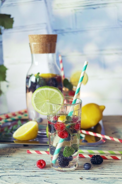 Detox drink from berries, mint and citruses in glasses and a decanter