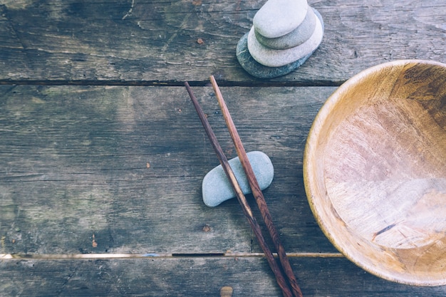 Detox food with empty wooden bowl and wooden chopsticks 