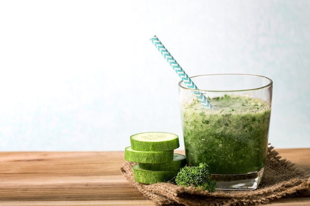 Detox green cucumber smoothie on a wooden table  , vegetable drink for health  