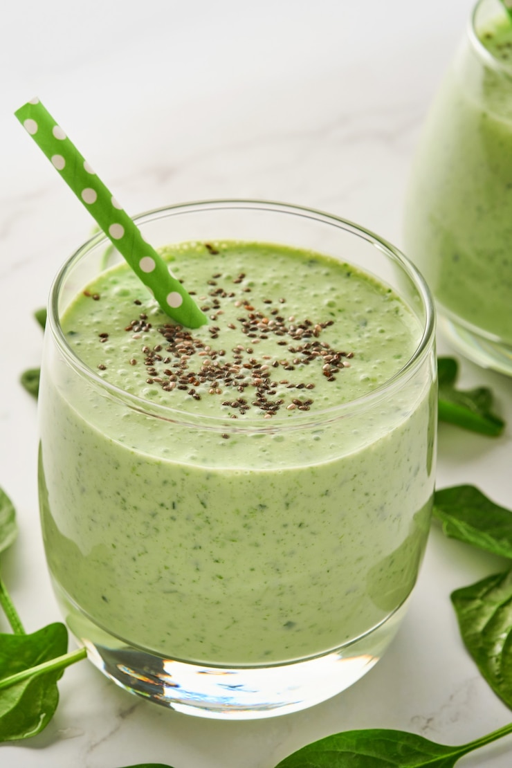 Photo detox green smoothie with spinach, chia seeds and kiwi on a light gray slate, stone or concrete table. top view