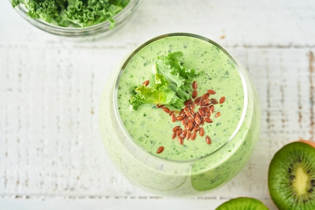 detox groene smoothie met boerenkool, spinazie en kiwi op een lichtgrijze leisteen