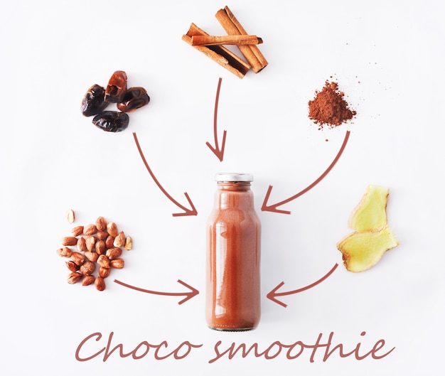 Detox healthy drink concept, chocolate smoothie ingredients. Natural, organic juice in bottle for weight loss diet or fasting day. Cocoa powder, ginger, date fruit and cinnamon mix isolated on white