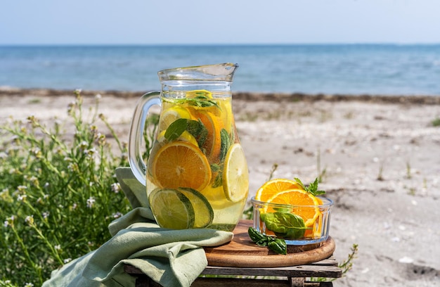 Detox infused water with lime oranges mint with sea coast view