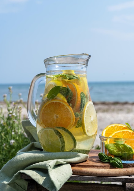 Detox infused water with lime oranges mint with sea coast view