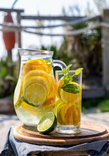 Detox infused water with lime oranges mint with sea coast view