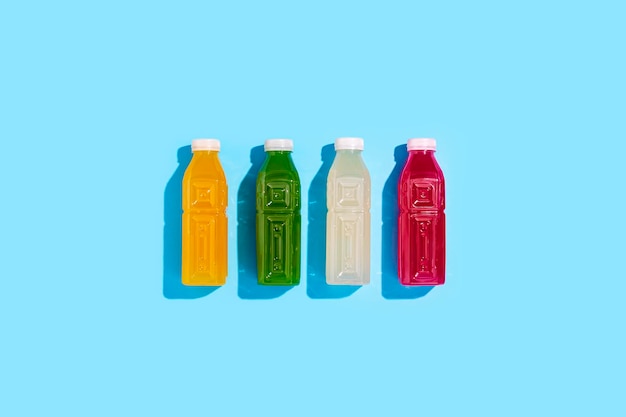 Detox juice drink in plastic bottles on a blue background. Top view, flat lay.