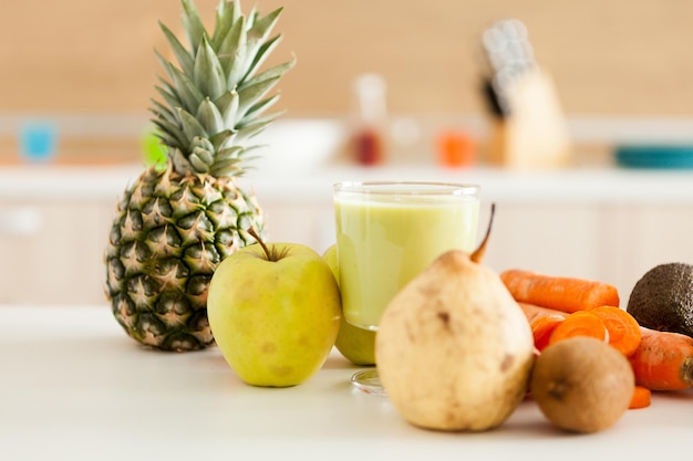 Detox juice next to fruits and vegetables at the kitchen