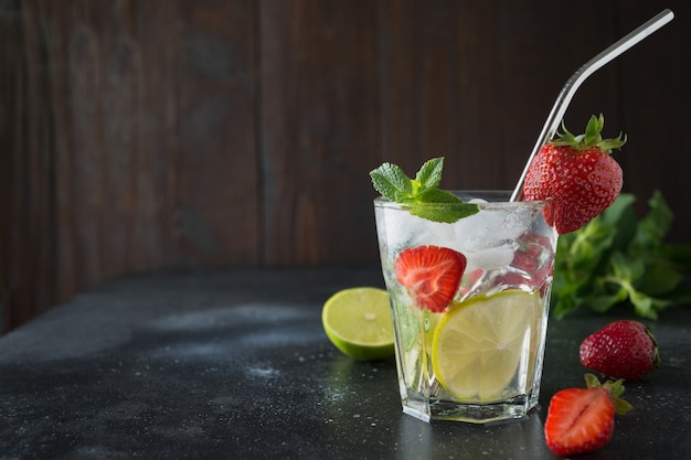 Detox lemonade or mojito with lime, lemon, strawberry in glass 