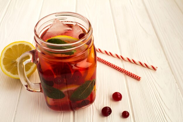 Detox water with cranberry, lemon and mint on the  white  wooden surface