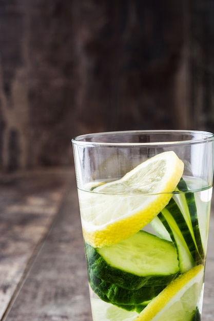 Detox water with cucumber and lemon on wooden table