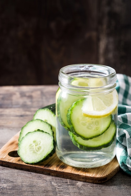 Detox water with cucumber and lemon on wooden table