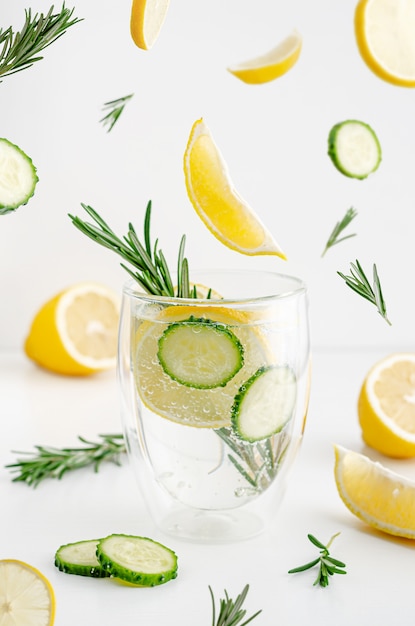 Detox water with lemon, cucumber and rosemary on white background