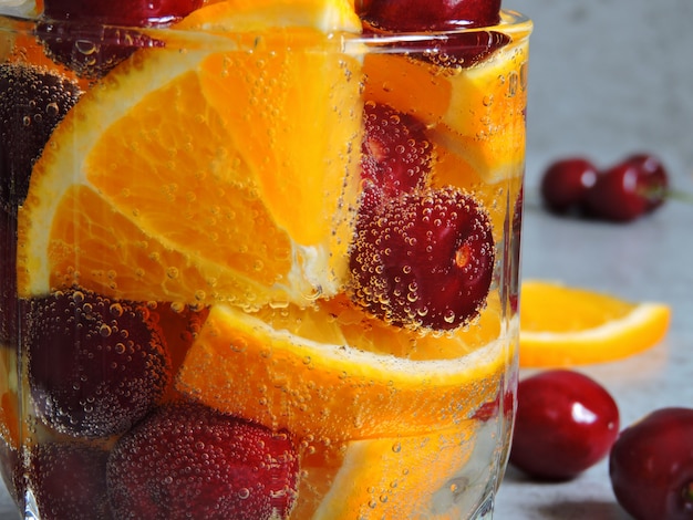 Detox water with orange and cherries.