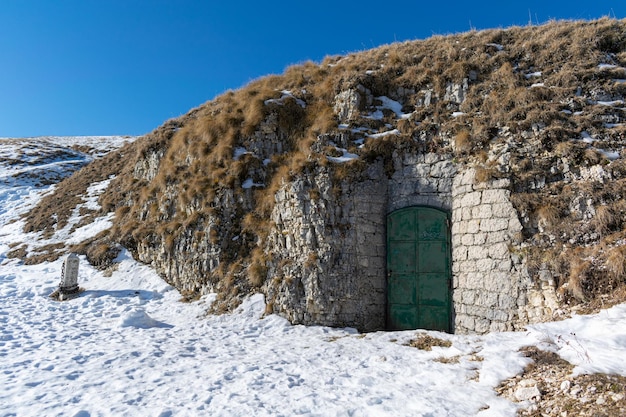 Deur toegang besneeuwde ondergrondse magazijn loopgraven Monte Grappa, Italië