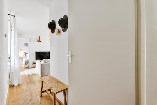 Deuropening van modern appartement met witte muren en parketvloer