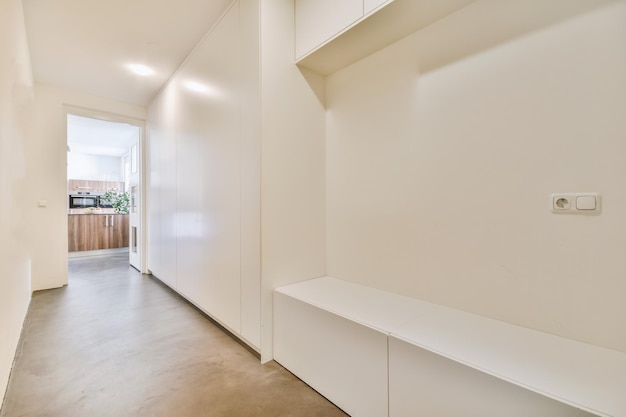 Deuropening van modern appartement met witte muren en parketvloer