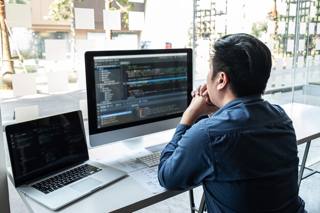 developer programmer working on project in software development computer in it company office, writing codes and data code website and coding database technologies to find solution to problem.