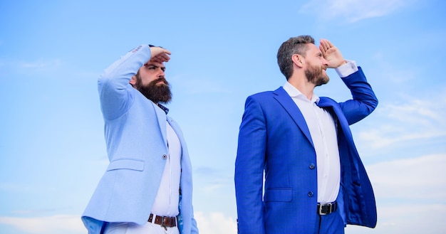 Developing business direction. Businessmen bearded faces stand back to back sky background. Men formal suit managers looking at opposite directions. Changing course. New business directions.