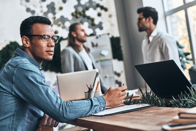 Photo developing new project. group of young modern people in smart casual wear discussing business while working in the creative office