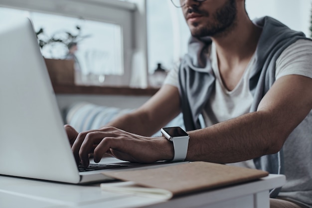 Developing new project using technologies. Close-up of young modern man using computer 