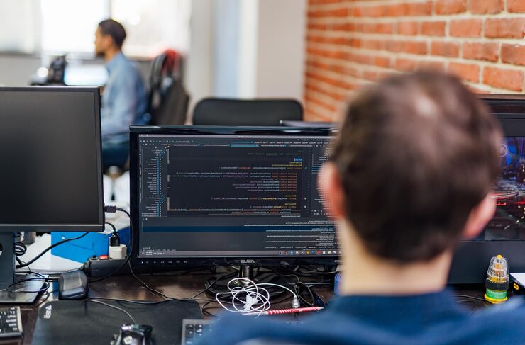 Photo developing programming and coding technologies website design programmer working in a software develop company office view from the back