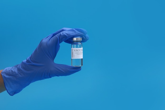 Development and creation of a coronavirus vaccine COVID-19 .Coronavirus Vaccine in glass bottle in hand of doctor on blue background.