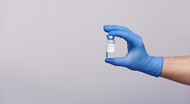 Development and creation of a coronavirus vaccine COVID-19 .Coronavirus Vaccine in glass bottle in hand of doctor on gray background.