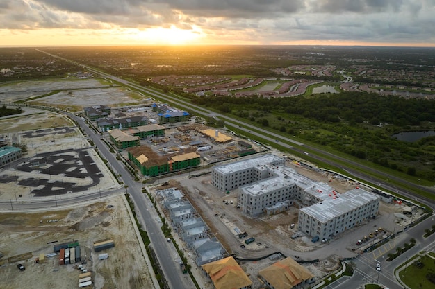 Development of residential housing in american suburbs Unfinished frames of apartment condos with wooden roof beams under construction Real estate market in the USA