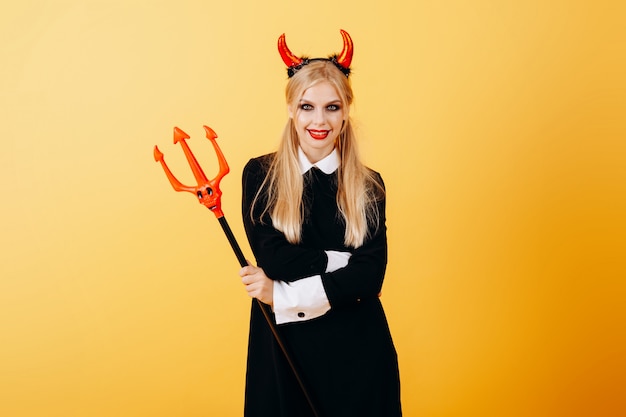 Photo devil woman standing against a yellow