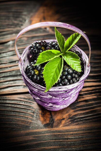 Dewberries in basket on vintage wooden board