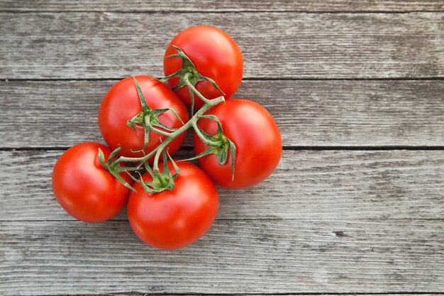 Dewy red tomatoes on the rustic wooden board