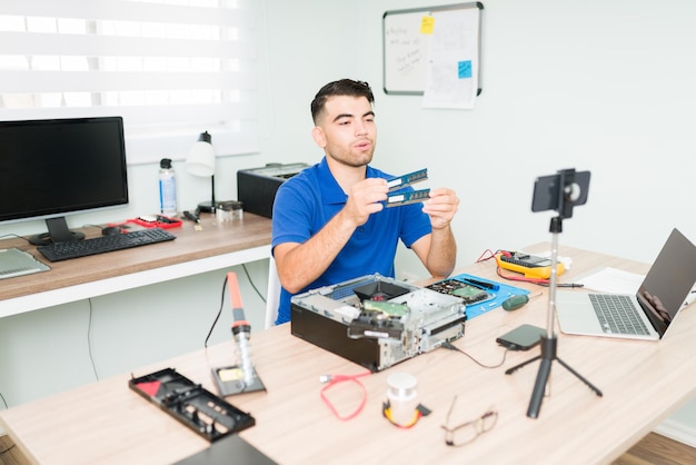 Deze computeronderdelen heb je nodig. Technicus en influencer live streamen op zijn social media kanaal terwijl hij aan het werk is in de reparatiewerkplaats