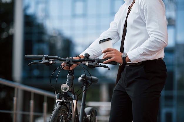 Foto deze man heeft geen auto nodig. zakenman in formele kleding met zwarte fiets is in de stad.