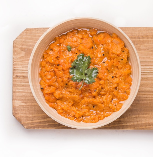 Dhal Indian cream lentil soup in a plate on a wooden board