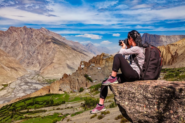 Dhankar gompa. Spiti-vallei, Himachal Pradesh, India. Natuurfotograaf toerist met camera schiet terwijl hij op de top van de berg staat.