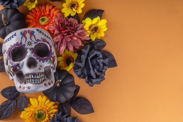 ディア・デ・ロス・ムエルトスの饗宴フラット横たわっていたメキシコ死者の日の休日の背景に秋の黒オレンジ黄色の花のライトボックスとテキストディア・デ・ロス・ムエルトスのカラフルな塗られた頭蓋骨